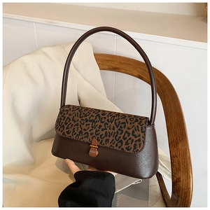 Detail van vintage bruine leren handtas met luipaardprint flap en gouden metalen gesp