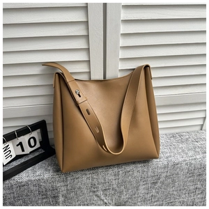 Detail of caramel leather tote bag with wide adjustable shoulder strap and metal rivets