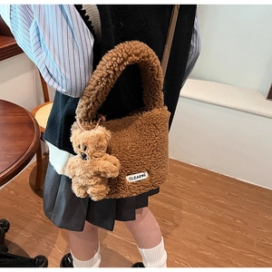 Detail of coffee brown plush bucket bag with cute bear charm and soft fleece texture