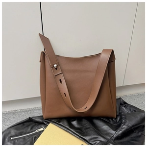 Detail of adjustable wide shoulder strap with silver buckle on brown tote bag