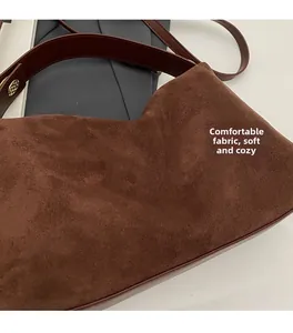 Détail en daim marron foncé doux avec garnitures dorées sur un grand sac hobo