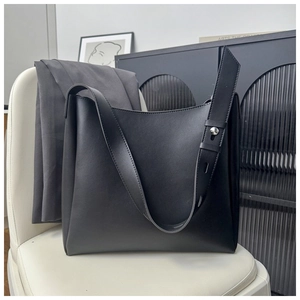 Detail view of black matte leather hobo bag with silver rivet on adjustable shoulder strap