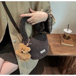 Close-up of plush dark brown bucket bag with fleece texture and cute bear pendant