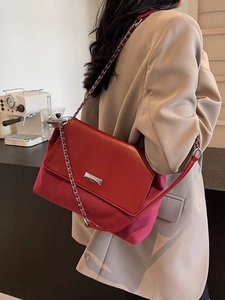 Retro dark red underarm bag with silver chain strap shown on a model's shoulder