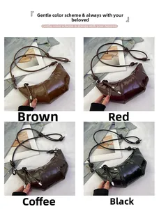 Detail view of crescent moon shoulder bags in shiny patent leather with knotted strap details