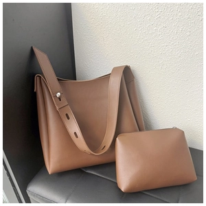 Close-up of brown matte leather tote bag and zipper pouch set with adjustable strap
