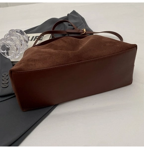Détail du sac docteur en daim marron avec structure vintage et fermoirs métalliques