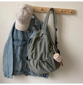 Detail view of water-resistant nylon backpack with cute plush charm and side pocket