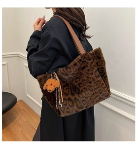 Detail of leopard print plush tote bag with brown faux fur and a poodle plush charm