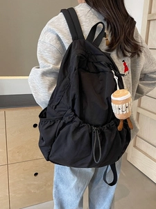 Lightweight black nylon backpack for women with a cute plush charm for casual travel