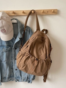 Minimalist camel drawstring backpack with large front pocket and wide straps for women