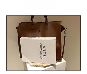 Borsa tote marrone in similpelle accanto a una scatola per confronto dimensioni