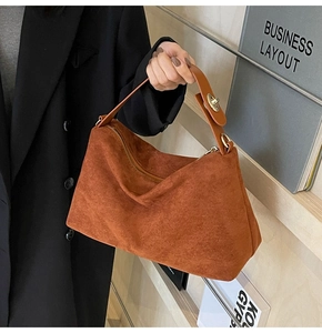 Vue détaillée du sac hobo en daim marron avec boucle dorée et poignée en cuir