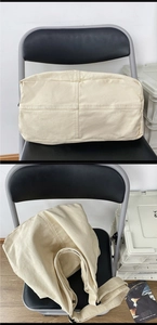 Detailed close-up of reinforced bottom stitching on an off-white canvas tote bag