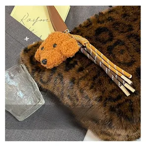 Detail of leopard print faux fur tote bag featuring a cute teddy dog plush charm and tassels