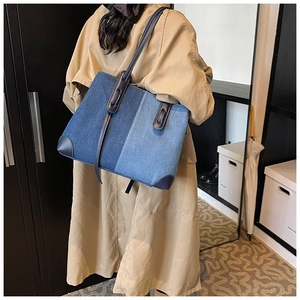 Λεπτομέρεια μεγάλης τσάντας denim με patchwork σχέδιο πάνω από μια χακί καμπαρντίνα