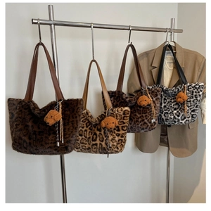 Detail view of four plush leopard print tote bags with soft fur and faux leather handles