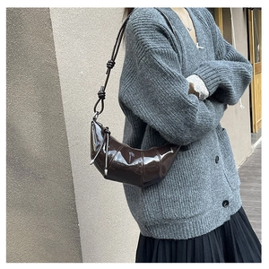 Detail shot of the dark brown patent leather hobo bag with a knotted shoulder strap style