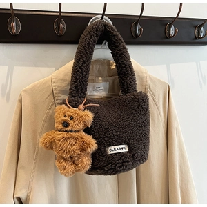 Detail of plush brown teddy tote bag with fluffy texture and cute bear charm accessory