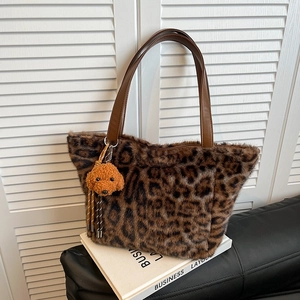 Large leopard print plush tote bag with leather handles and dog charm accessory