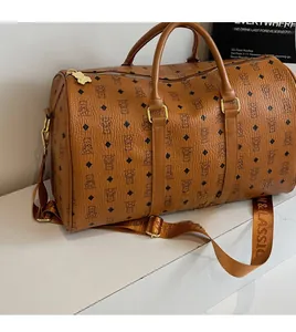 Detail of a brown leather travel bag with bear patterns and a stylish wide shoulder strap