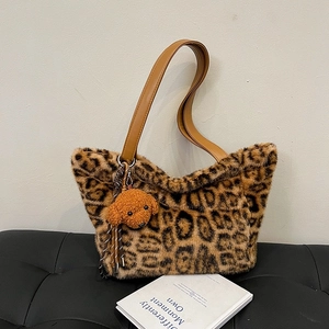 Large leopard print plush tote bag with brown leather straps and puppy charm pendant