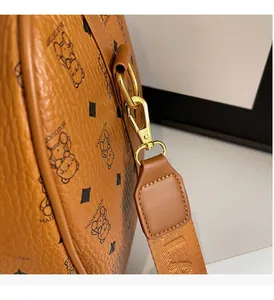 Detail of cognac leather bag with bear print and gold-toned metal lobster clasp and D-ring