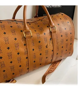 Close-up of the brown leather travel bag with teddy bear pattern and sturdy metal hardware