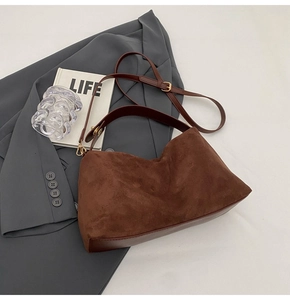Vue détaillée du sac Boston en daim marron foncé avec finitions dorées et cuir lisse