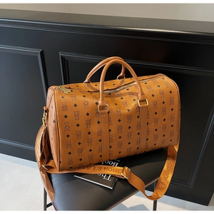 Detail of bear monogram pattern on brown faux leather travel bag with gold hardware