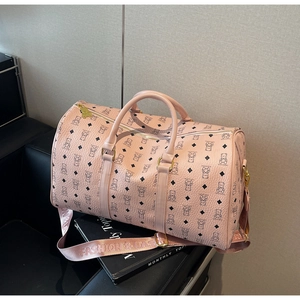 Macro shot of pink travel bag featuring bear prints, faux leather texture, and gold buckles