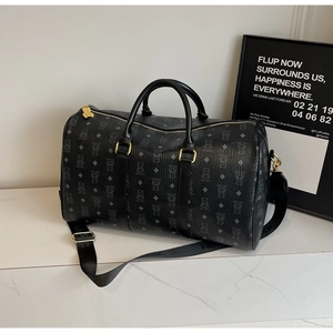 Detail of a large black Boston travel bag with bear pattern and gold metal hardware