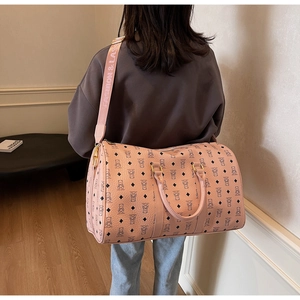 Detail of pink travel bag with cartoon bear pattern and adjustable logo shoulder strap