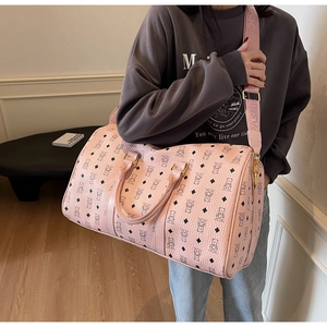 Pink Boston bag with bear and diamond patterns shown on model in cozy interior setting