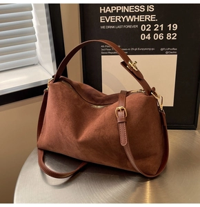 Détails de la texture en daim marron foncé et des finitions métalliques dorées du sac