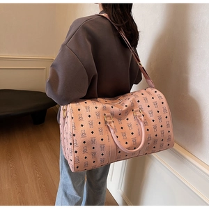Close-up of pink leather travel bag featuring teddy bear print and adjustable strap