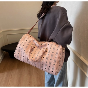 Detail of pink faux leather travel bag with bear pattern and adjustable shoulder strap