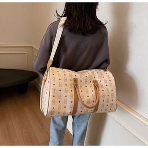 Detail of large travel bag featuring brown bear patterns and wide fashion shoulder strap