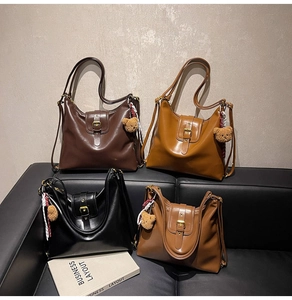 Close-up of vintage faux leather tote bags in four colors with bear charms on a sofa