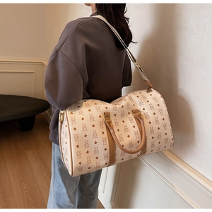 Detailed view of the large cream travel bag with bear pattern worn as a crossbody bag