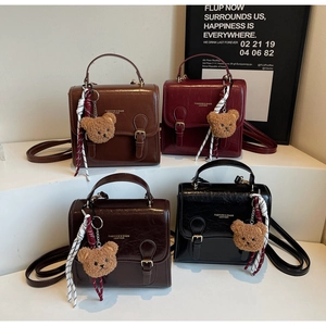 Detail view of retro mini backpacks in four colors with teddy bear charms and ribbon