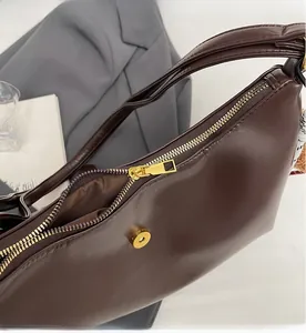 Detail of smooth gold zipper and magnetic closure on a vintage dark brown tote bag