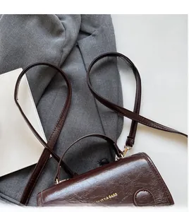 Close-up of dark brown vintage leather crossbody bag featuring fine lychee grain texture