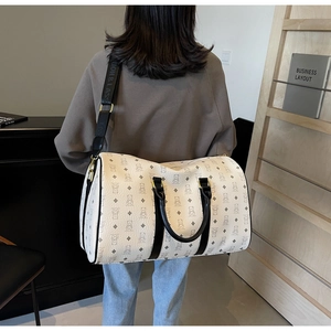 Detail of cream large travel bag featuring bear patterns and a stylish wide shoulder strap