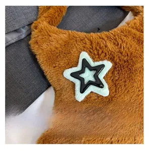 Macro detail of brown plush material with a composite star emblem on the crossbody bag
