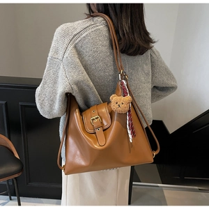 Caramel brown vintage tote bag with gold buckle and a cute teddy bear charm