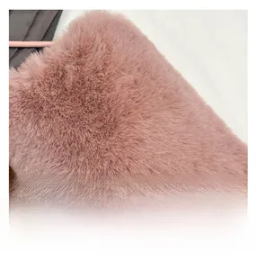 Gros plan sur la fourrure synthétique rose doux montrant une texture dense et de qualité
