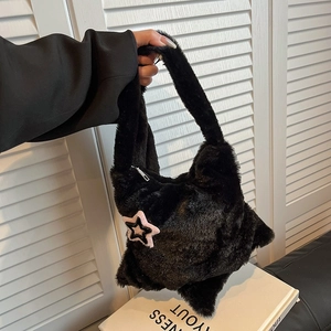 Detailed close-up of soft black plush star-shaped handbag with premium silver zipper
