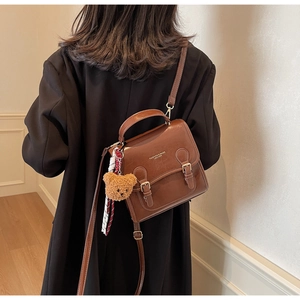 Brown retro PU leather handbag with gold buckles, plush bear charm, and decorative scarf