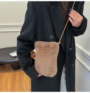 Détail de la pochette bandoulière en peluche marron avec breloque et sangle